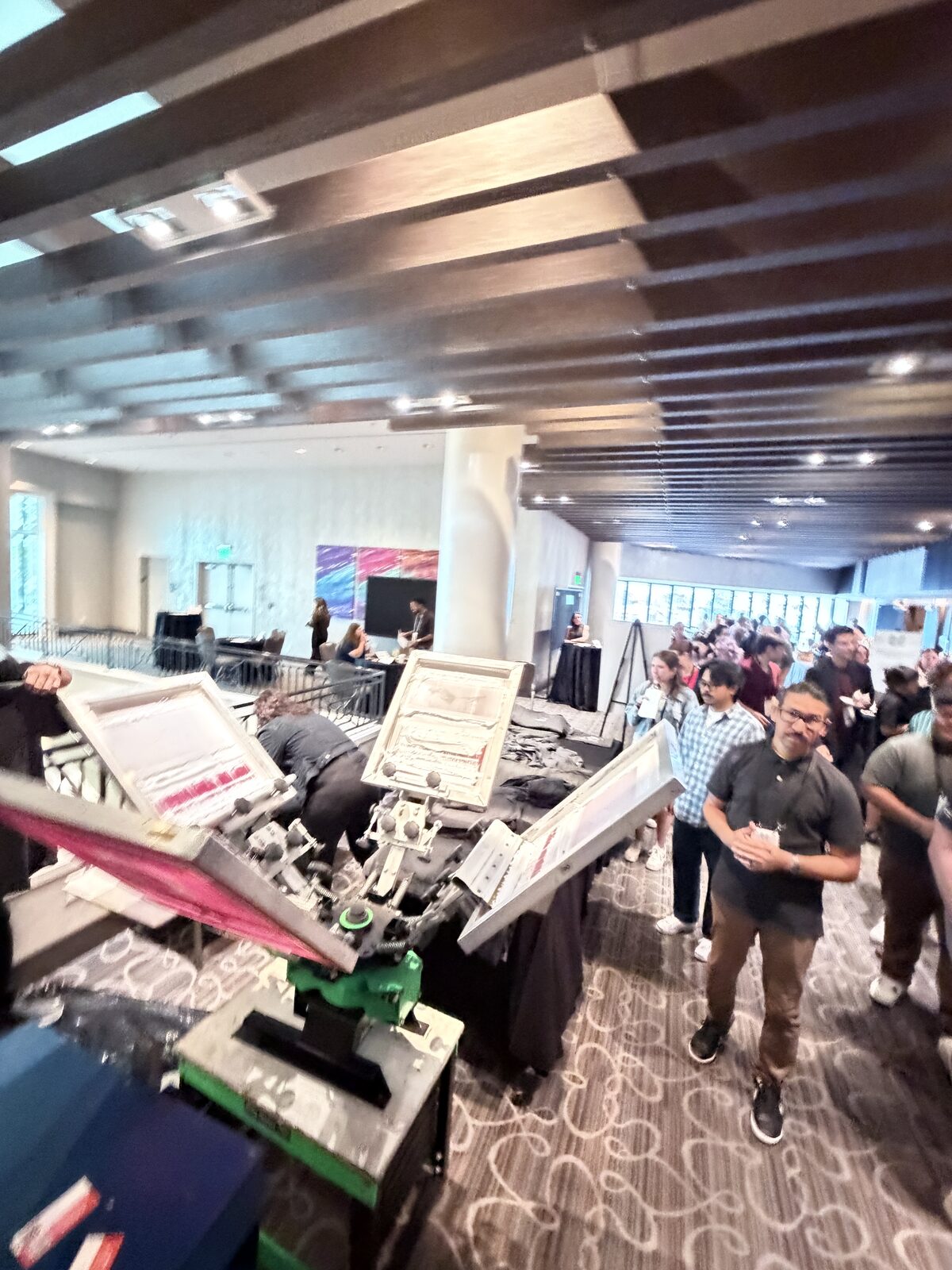 Guests watching a printer pull a squeegee at a Los Angeles event